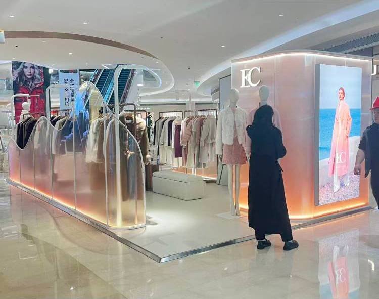 White bespoke clothing showcase installed in shopping mall concession booth